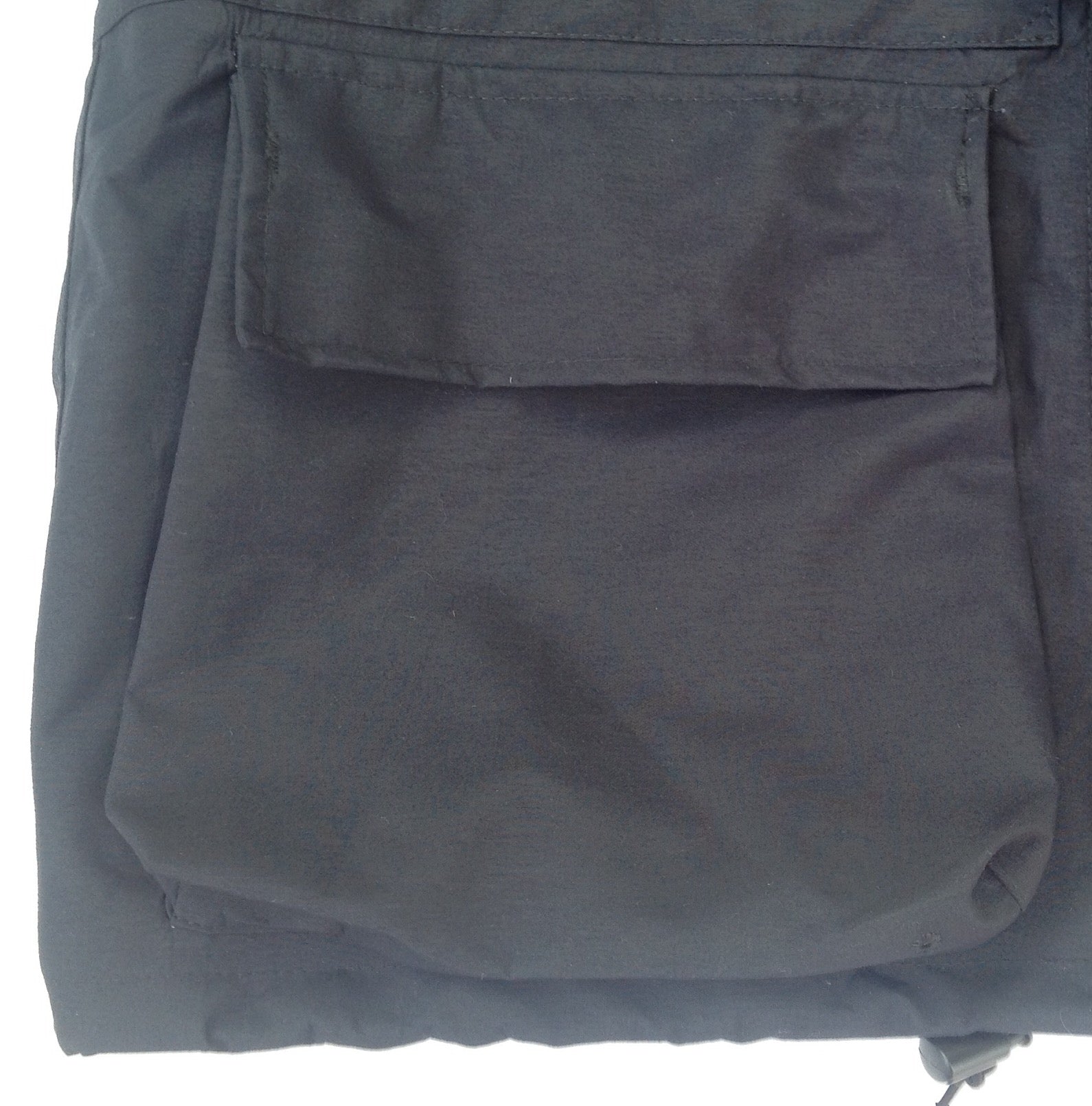 La veste dispose de deux grandes poches plaquées situées sur la partie basse, avec rabats supérieurs fermés par velcro.